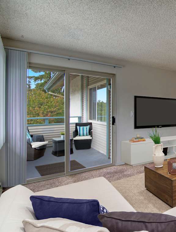A living room with a white couch and a flat screen TV.