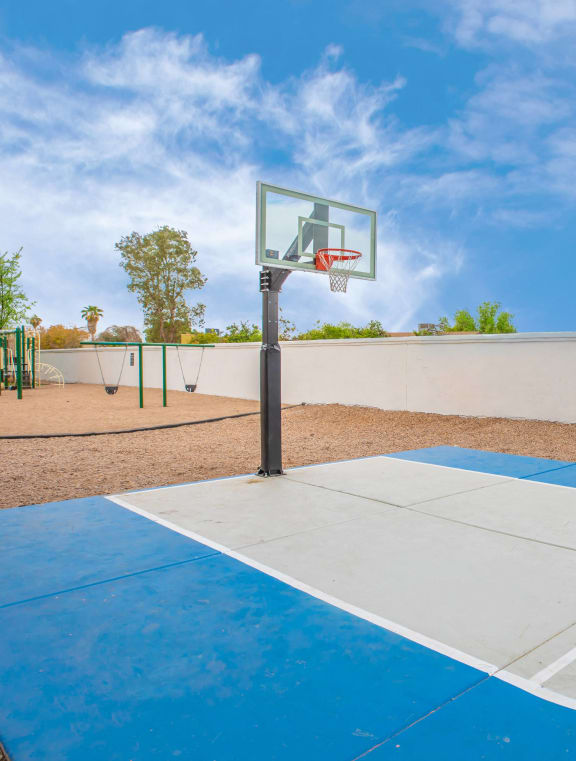 a courtyard with a playground and yellow chairs in front of an apartment building