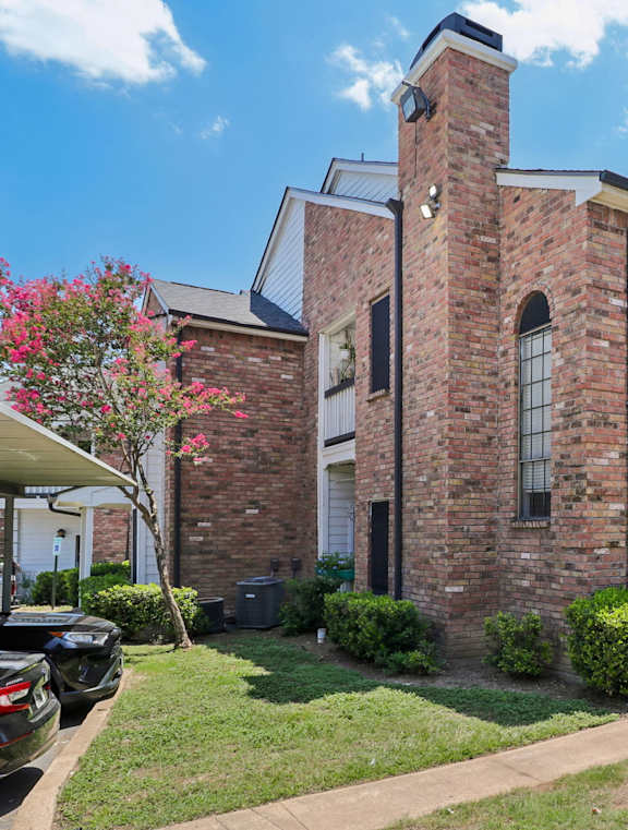 A brick house with a white door and windows.