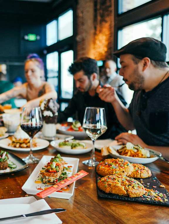 A woman is eating in a restaurant with a group of people.