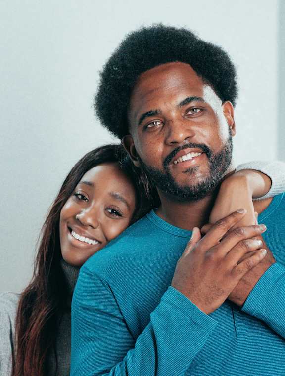 A man and woman are embracing, with the woman holding a key.