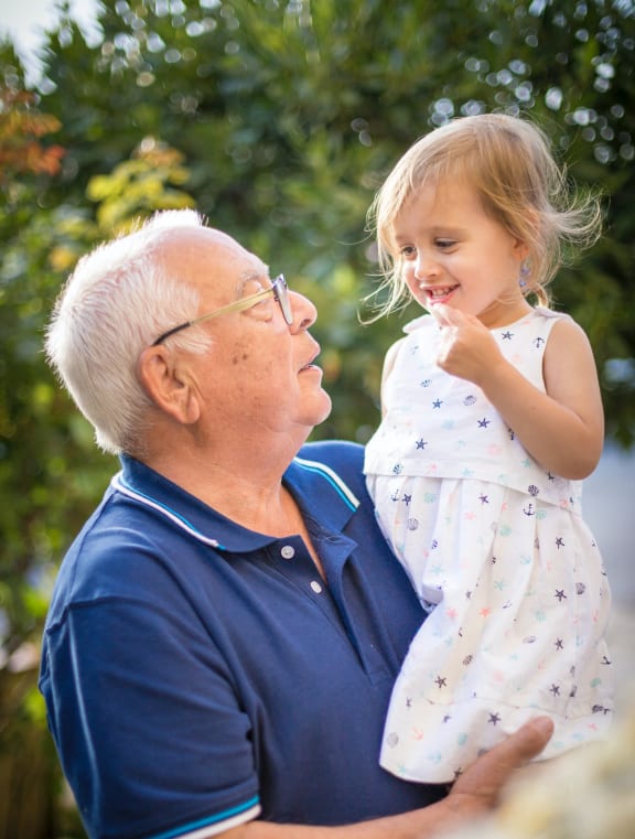 an older man holding a little girl in his arms