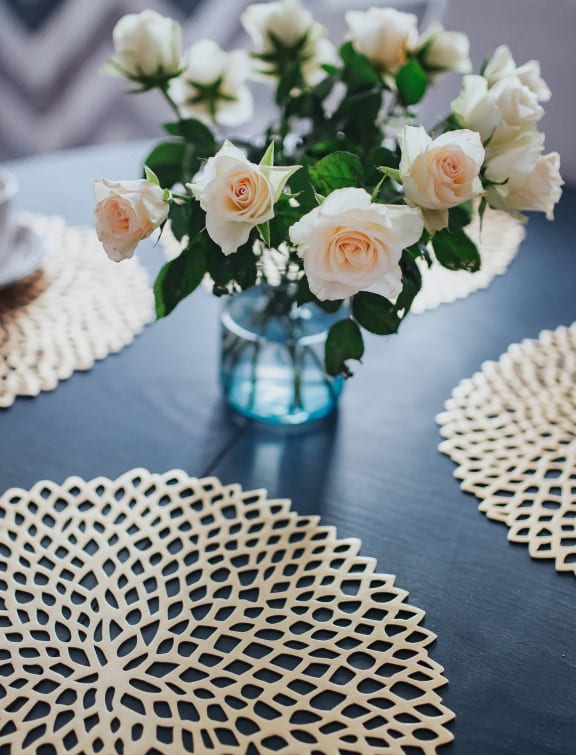 a table with a vase of flowers and a coffee cup on it