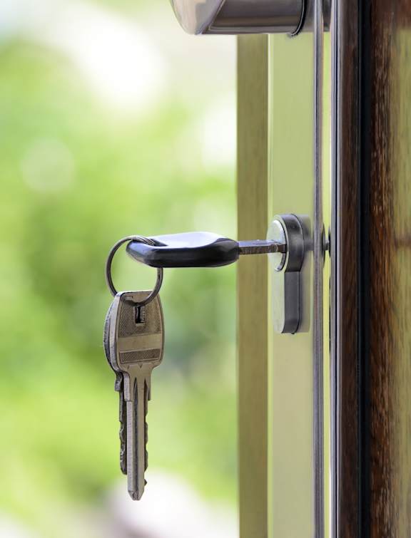 A bunch of keys hanging from a door handle.