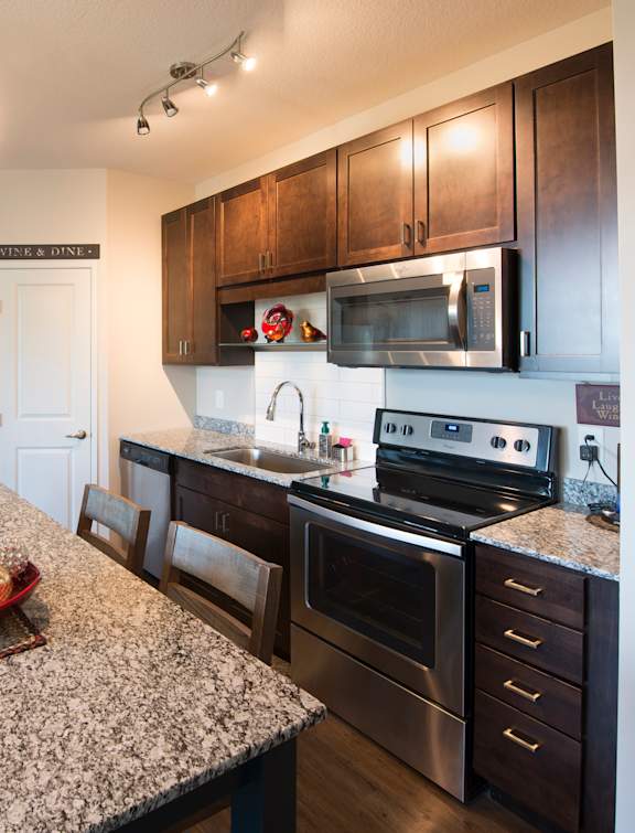 A kitchen with granite countertops and stainless steel appliances.
