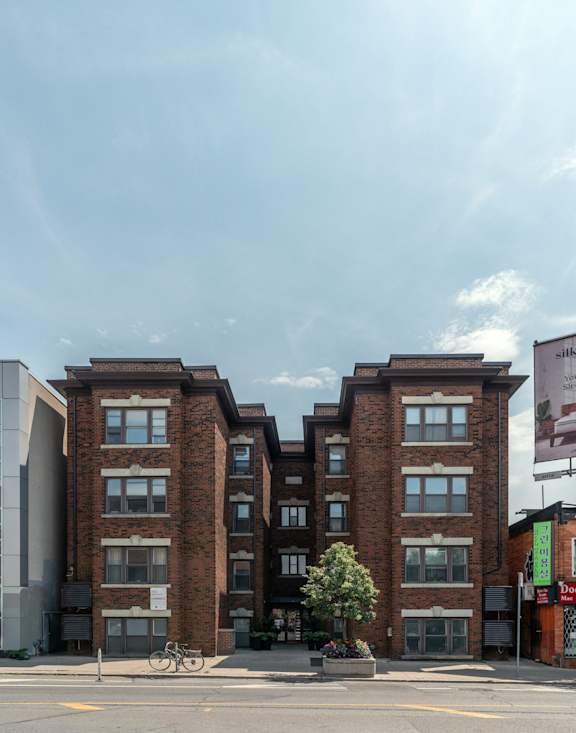 a large kitchen with white cabinets and marble counter tops at 723 Bloor Apartments, Canada, M6G 1L5