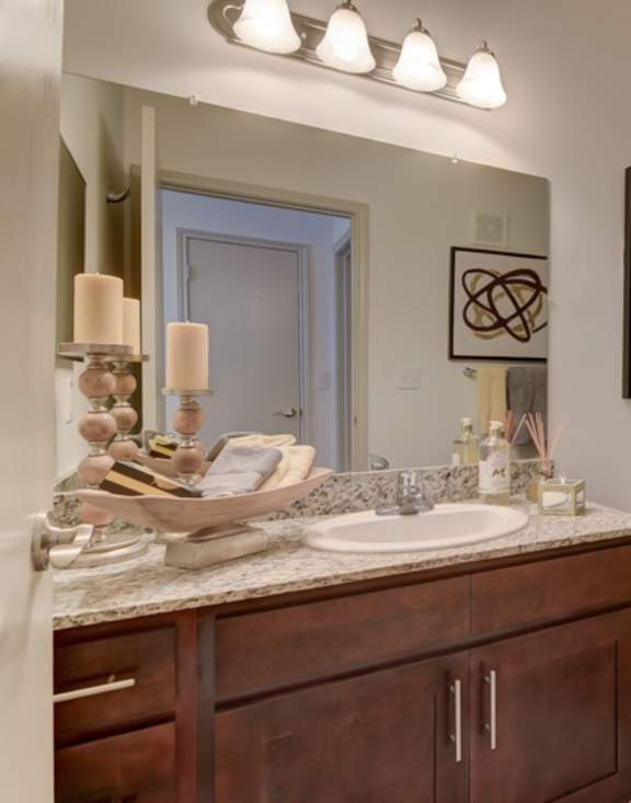 A bathroom with a white toilet, a sink, and a mirror.