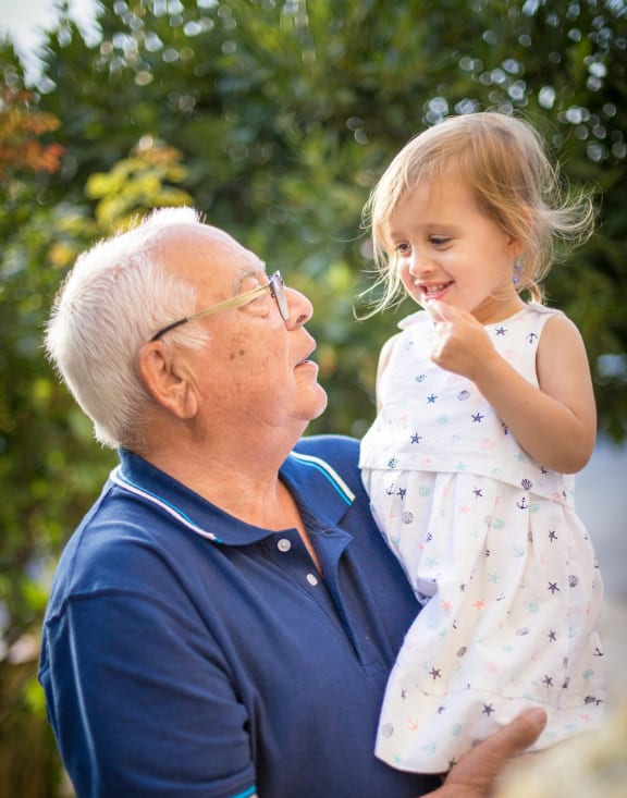 an older man holding a little girl in his arms