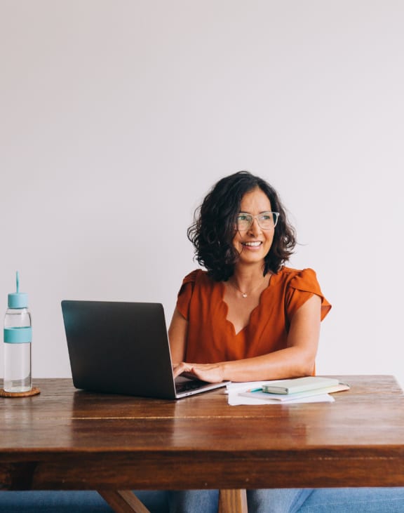 a woman with two young girls looking at a laptop