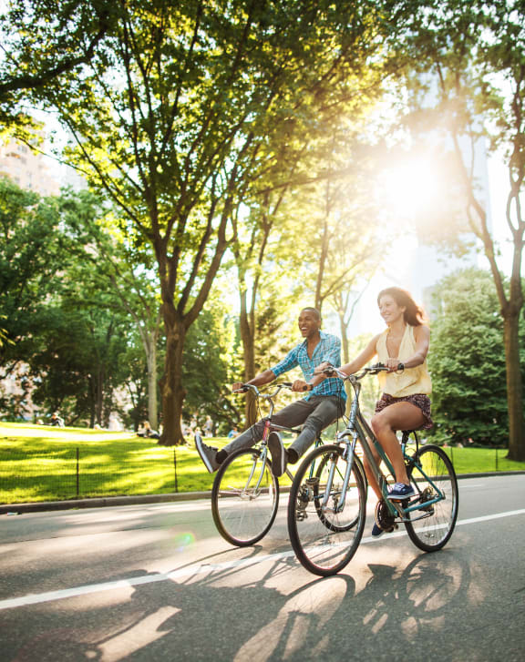 a man and a woman riding bikes down the street at Audubon Oaks, FL