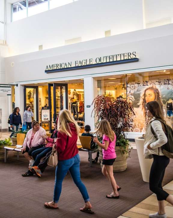 Shoppers are walking through the entrance of the American Eagle Outfitters store.