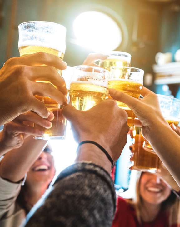 A group of people clinking glasses together in a celebratory toast. at Life At Agora Apartments, Cleveland, Ohio