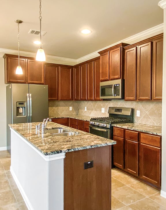 a kitchen with wooden cabinets and granite countertops