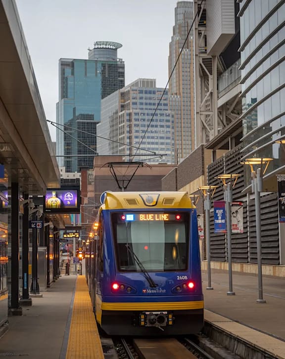 A blue train is on the tracks at a station.