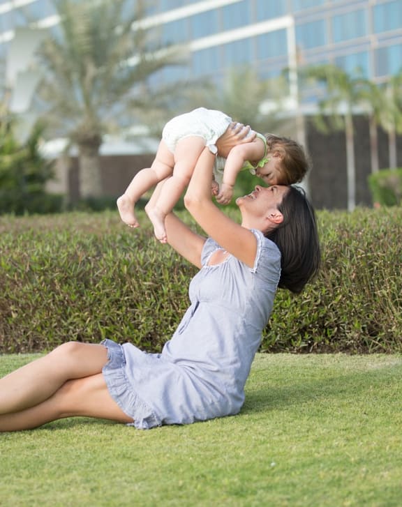 a mother playing with her daughter on the grass