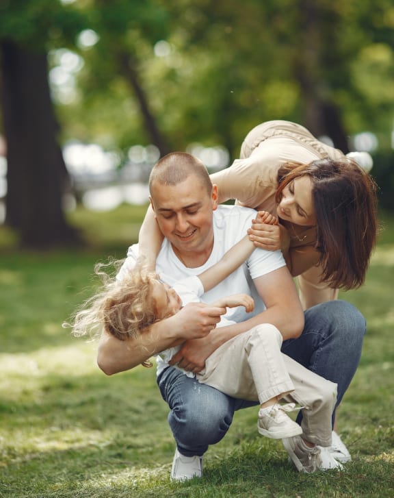 portrait of a young family with a little daughter in the park free photo