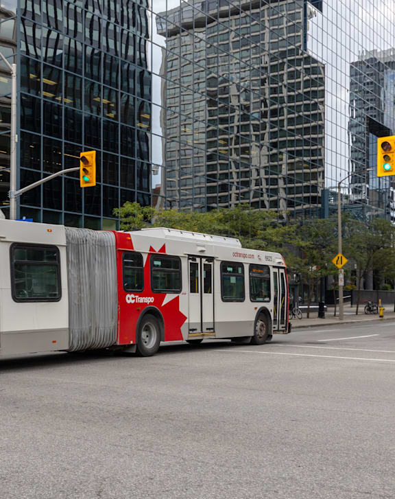 A red train with the logo "CC Transpo" on the front is at a station.