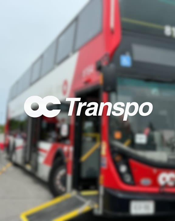 A red train with the logo "CC Transpo" on the front is at a station.