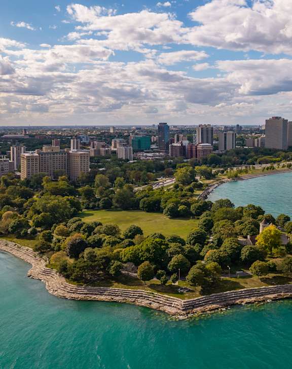 A small island with a lot of trees in the middle of a large body of water.