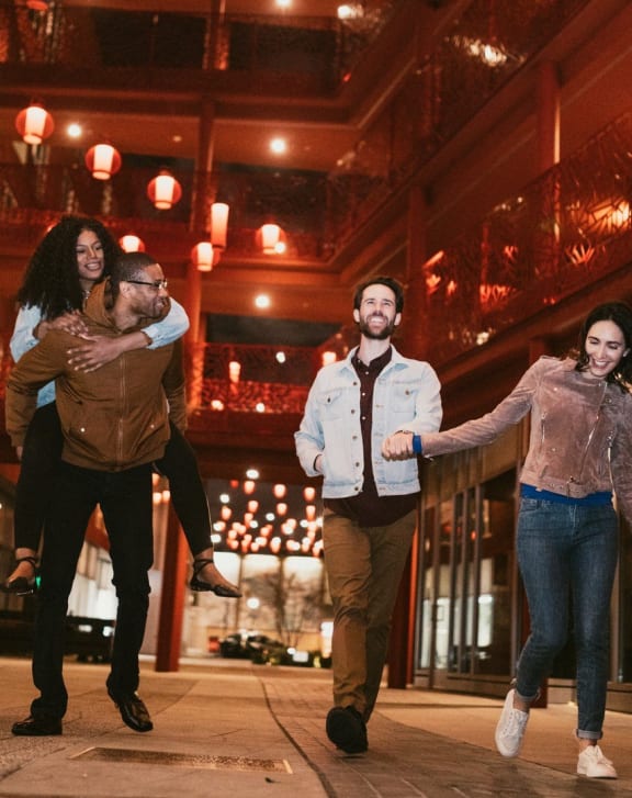 a group of people walking down a city street at night