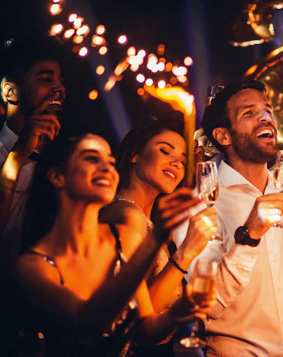 a group of people celebrating at a party with sparklers