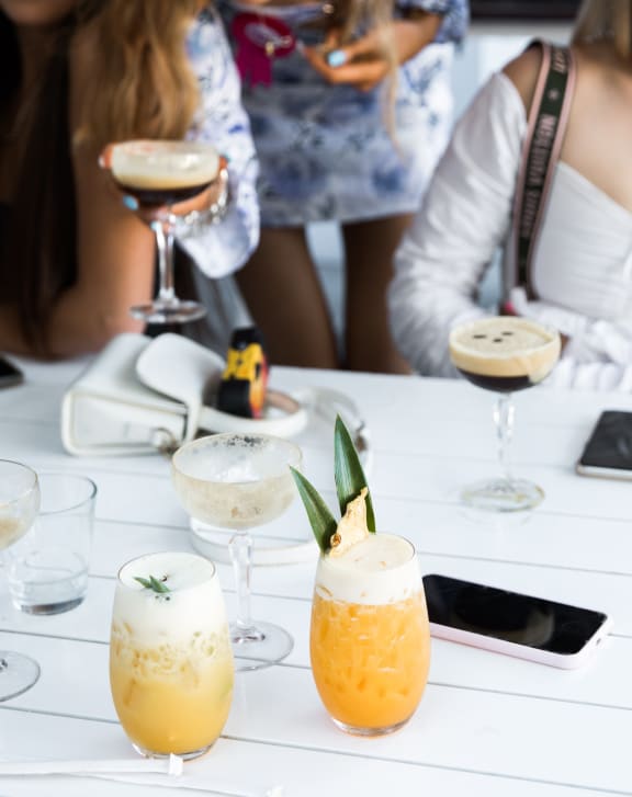 cocktails on a table with people in the background