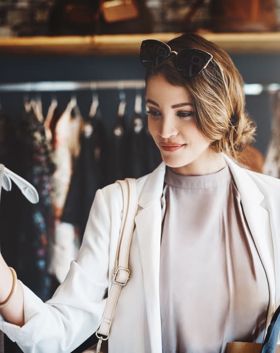 a woman looking at clothes on a rack