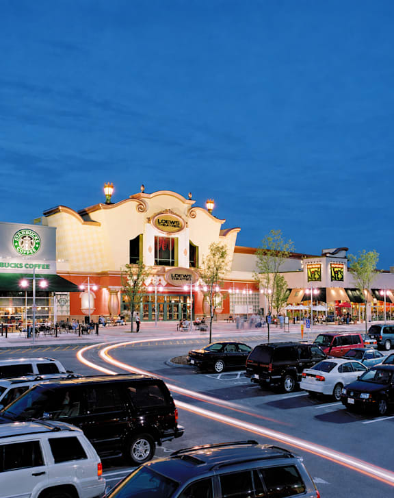 A parking lot with cars and a Starbucks Coffee store in the background.