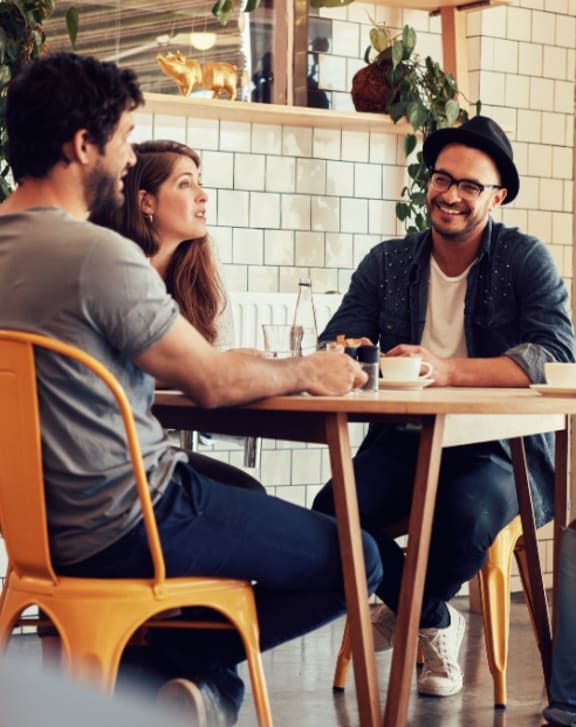 Four people sitting around a table in a cafe.