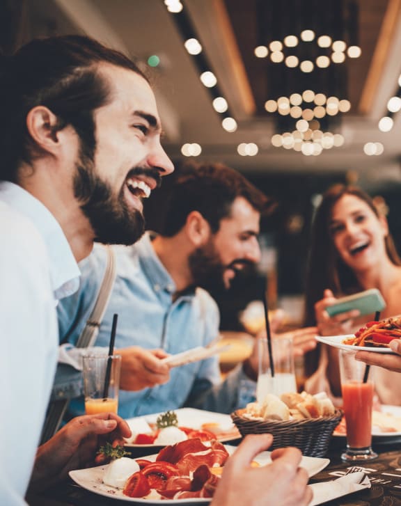a group of people eating food at a table in a restaurant