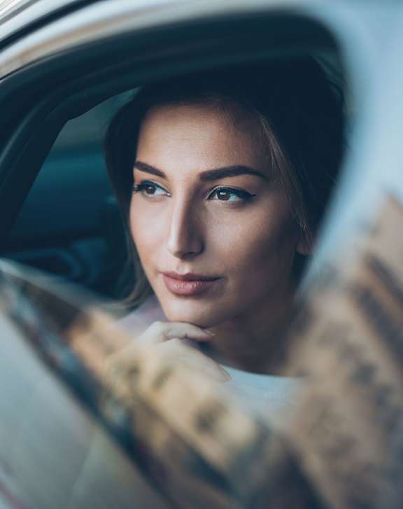 A woman is sitting in a car at Burbank Gardens Apartments, California