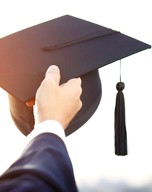 Person in a suit is holding a graduation cap at The Crest at Oakwood, Georgia, 30566