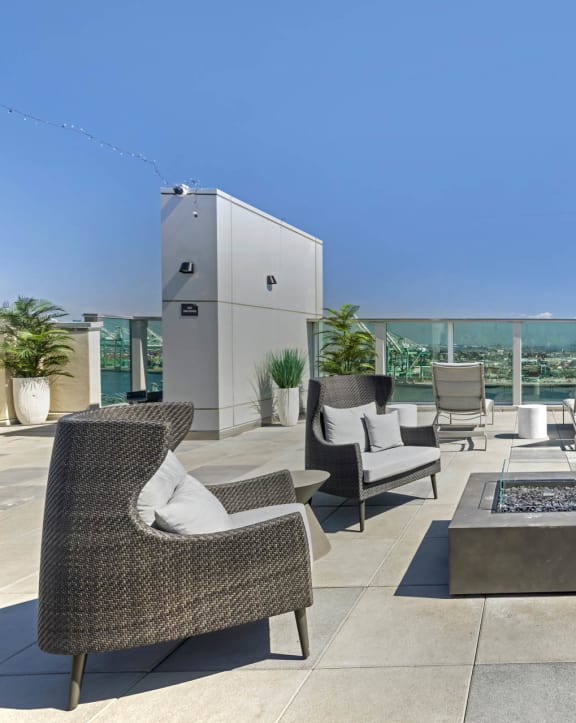 a roof top patio with chairs and a fire pit at Vue, San Pedro, CA