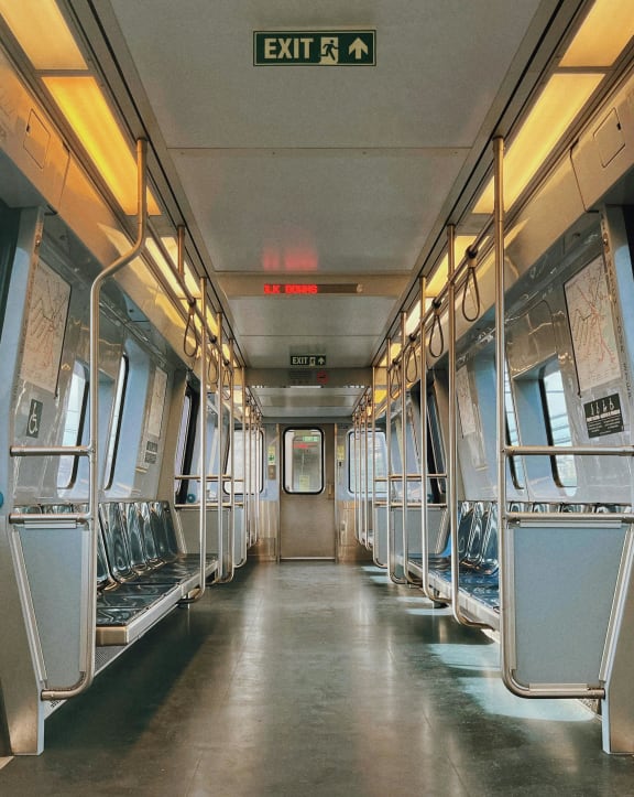 a subway train with empty seats and a exit sign