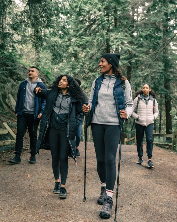 a group of people walking on a trail in the woods