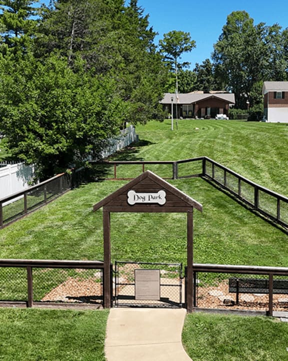 A sign that says "Deer Park" is in front of a green field.