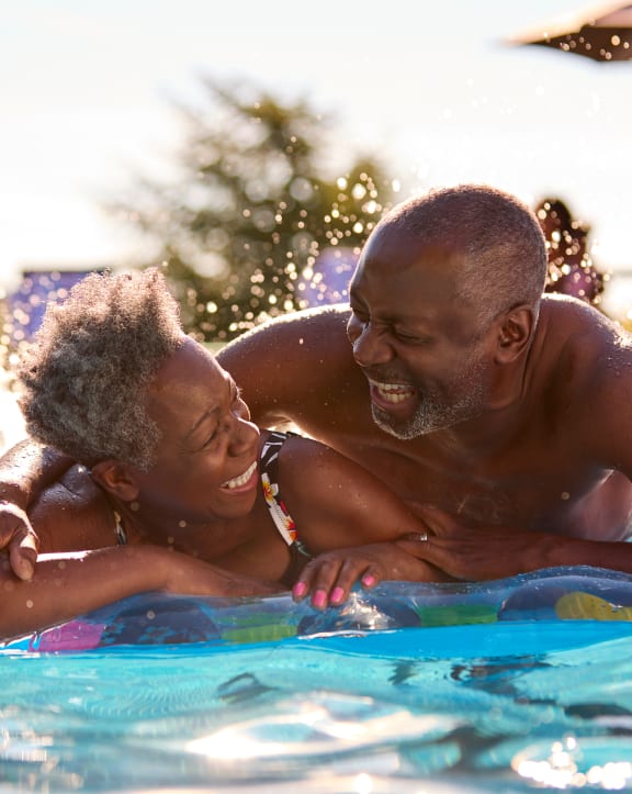 a father and daughter playing in a pool
