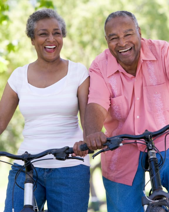an older couple riding bikes in the park