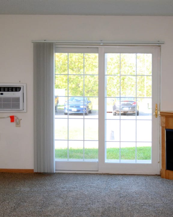 a living room with two large glass doors and a fireplace