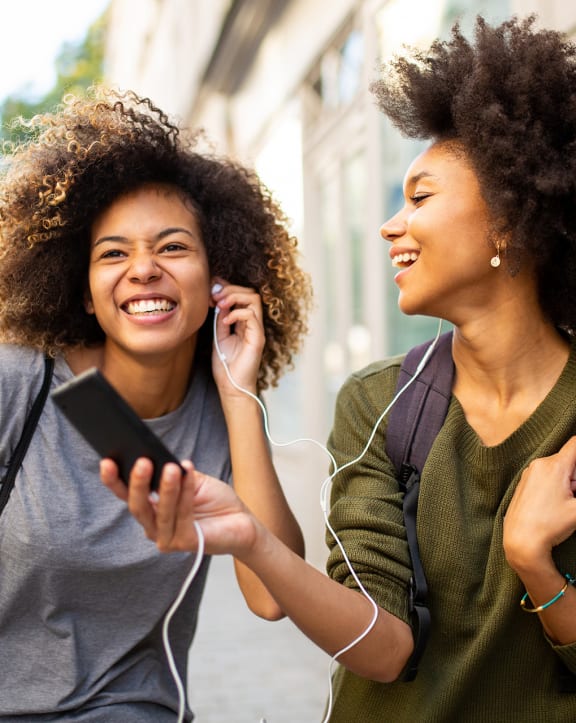 two women walking down the street and talking on the phone
