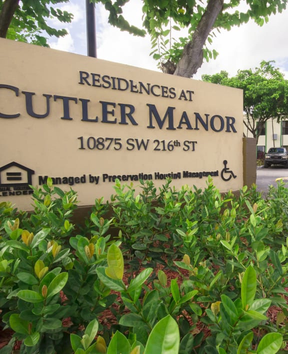 a picture of theucci manor sign in front of the building
