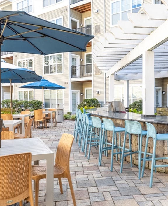 a patio with tables and chairs and umbrellas