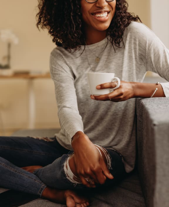 a woman sitting on the floor with a cup of coffee