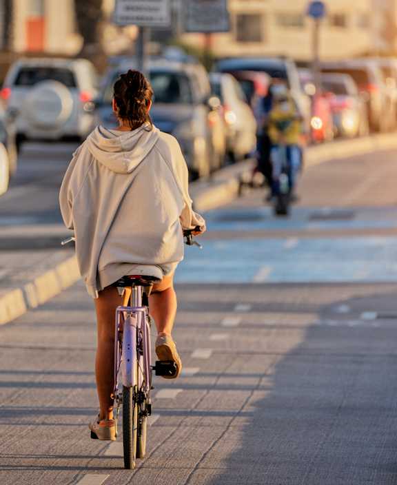 A man and a woman are riding bicycles on a sandy beach.