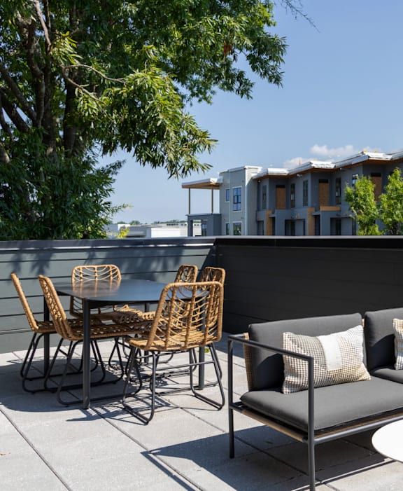 A patio with a table and chairs overlooking a building.