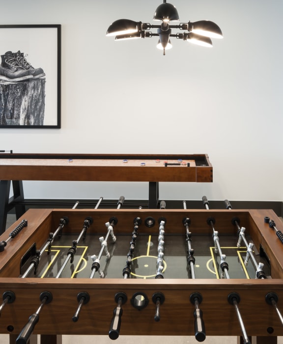 a foosball table sits in the center of a room with a tv on the wall