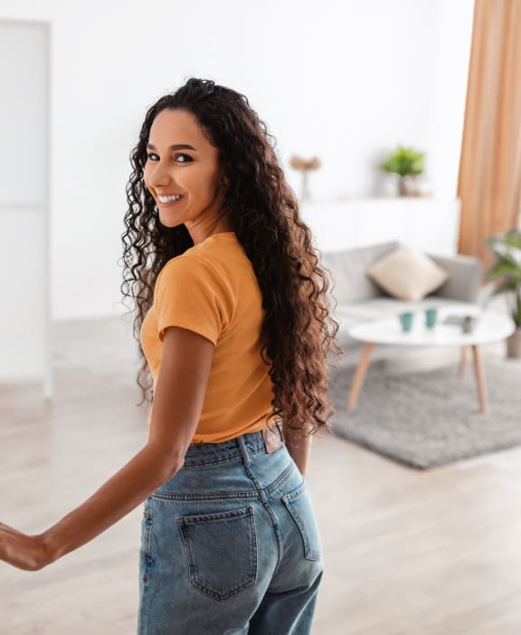 young woman opening the door to her apartment