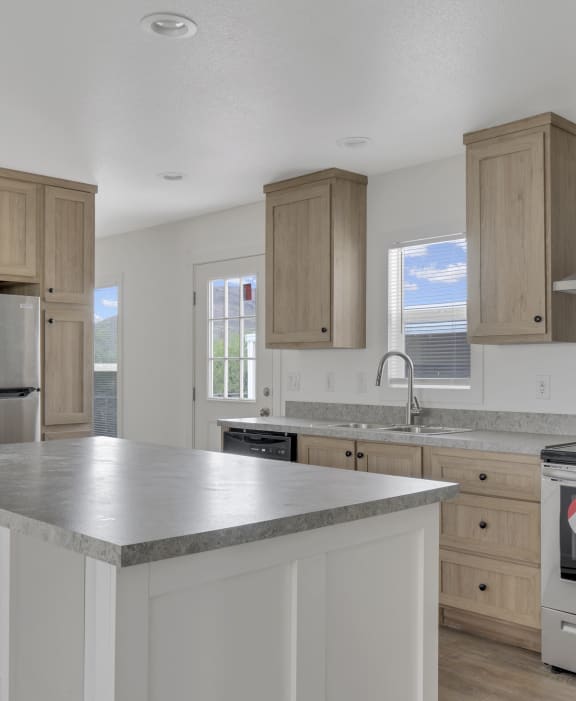 a kitchen with a large island and stainless steel appliances