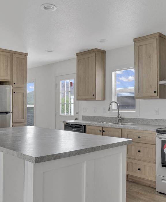 a kitchen with a large island and stainless steel appliances