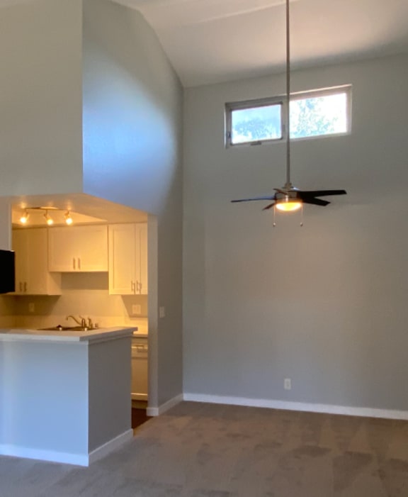 A room with a ceiling fan and a window.